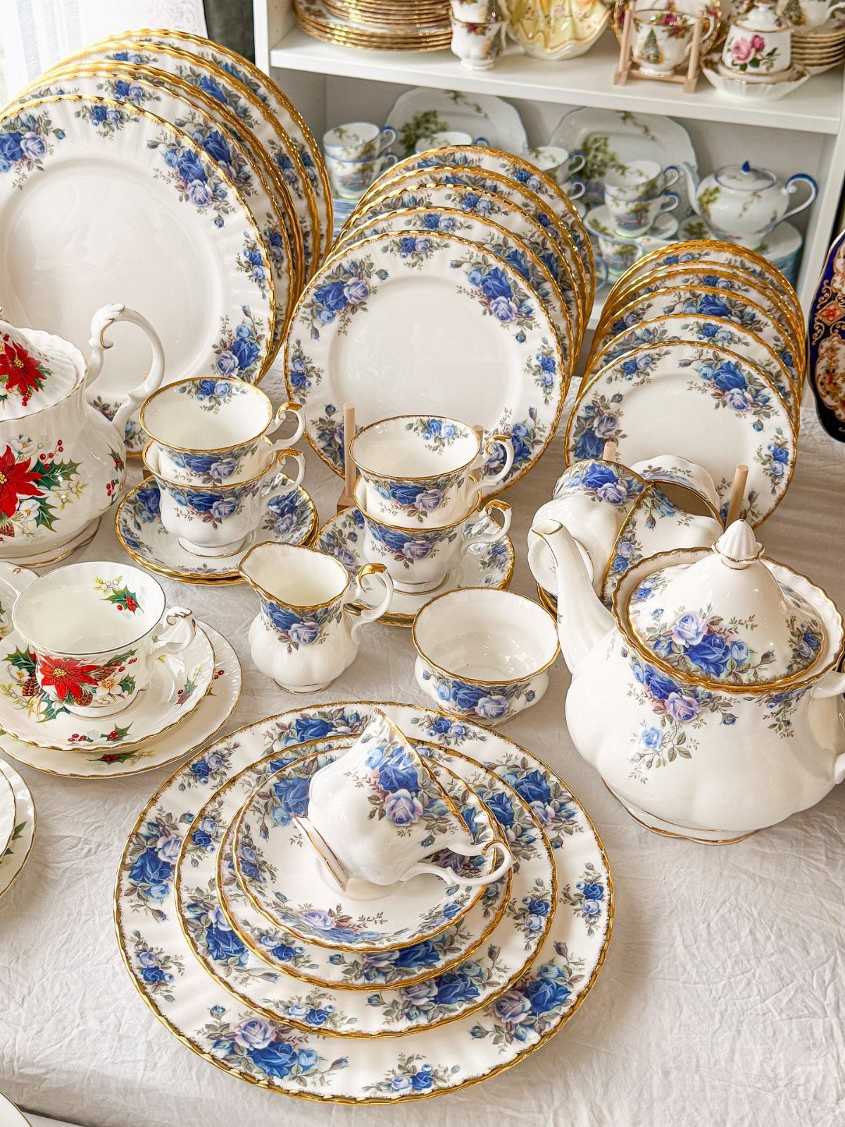 White porcelain dinnerware set with blue floral patterns and gold gilded edges.