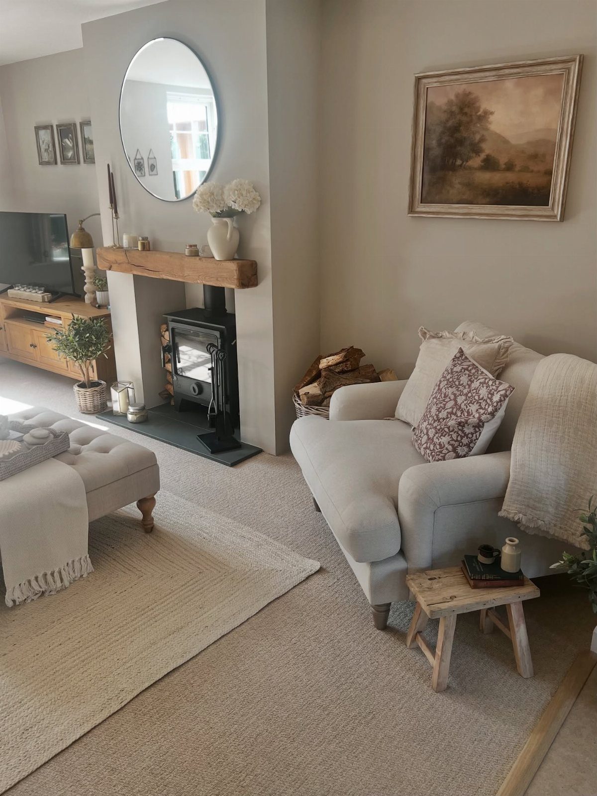 Cozy living room with oak mantel, oak furniture, and a white armchair.